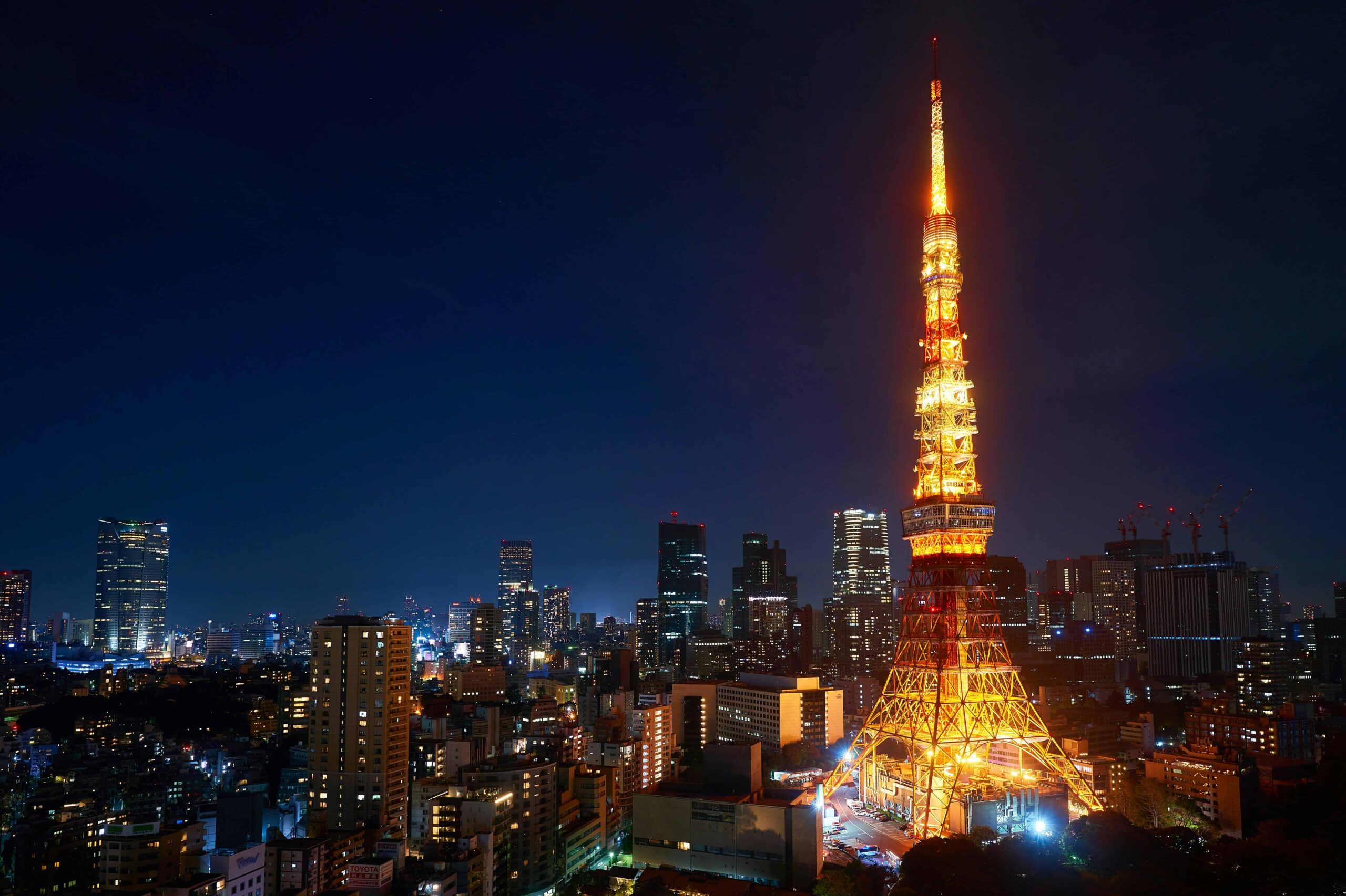 Tokyo Tower illuminated at night against the vibrant city skyline