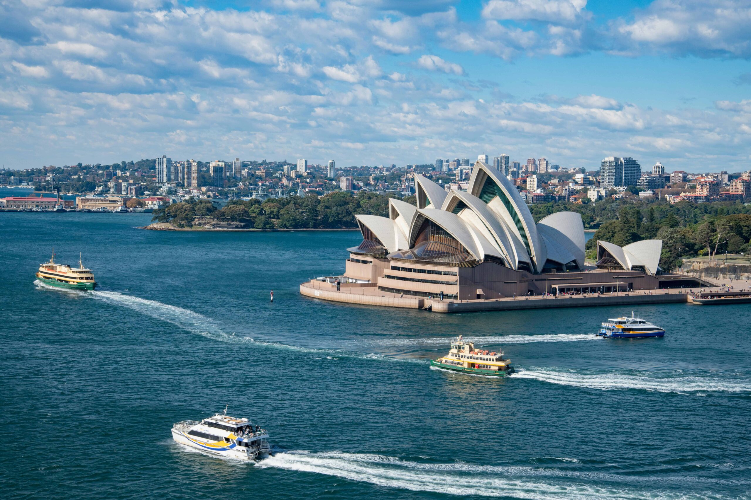 Sydney Opera House with ferries sailing in Sydney Harbour on a clear day