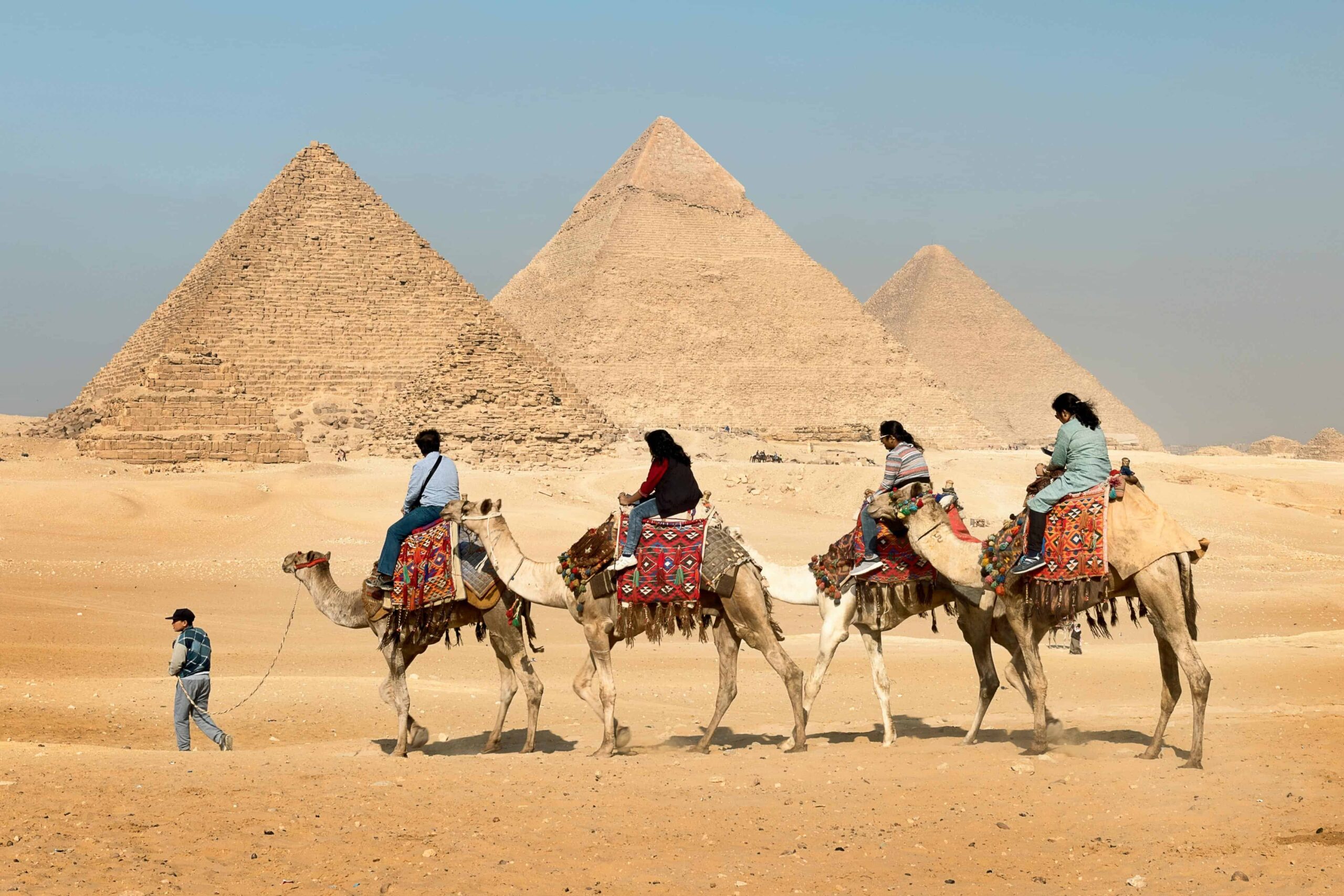 Egypt,Four People Riding on Camels Across the Pyramids